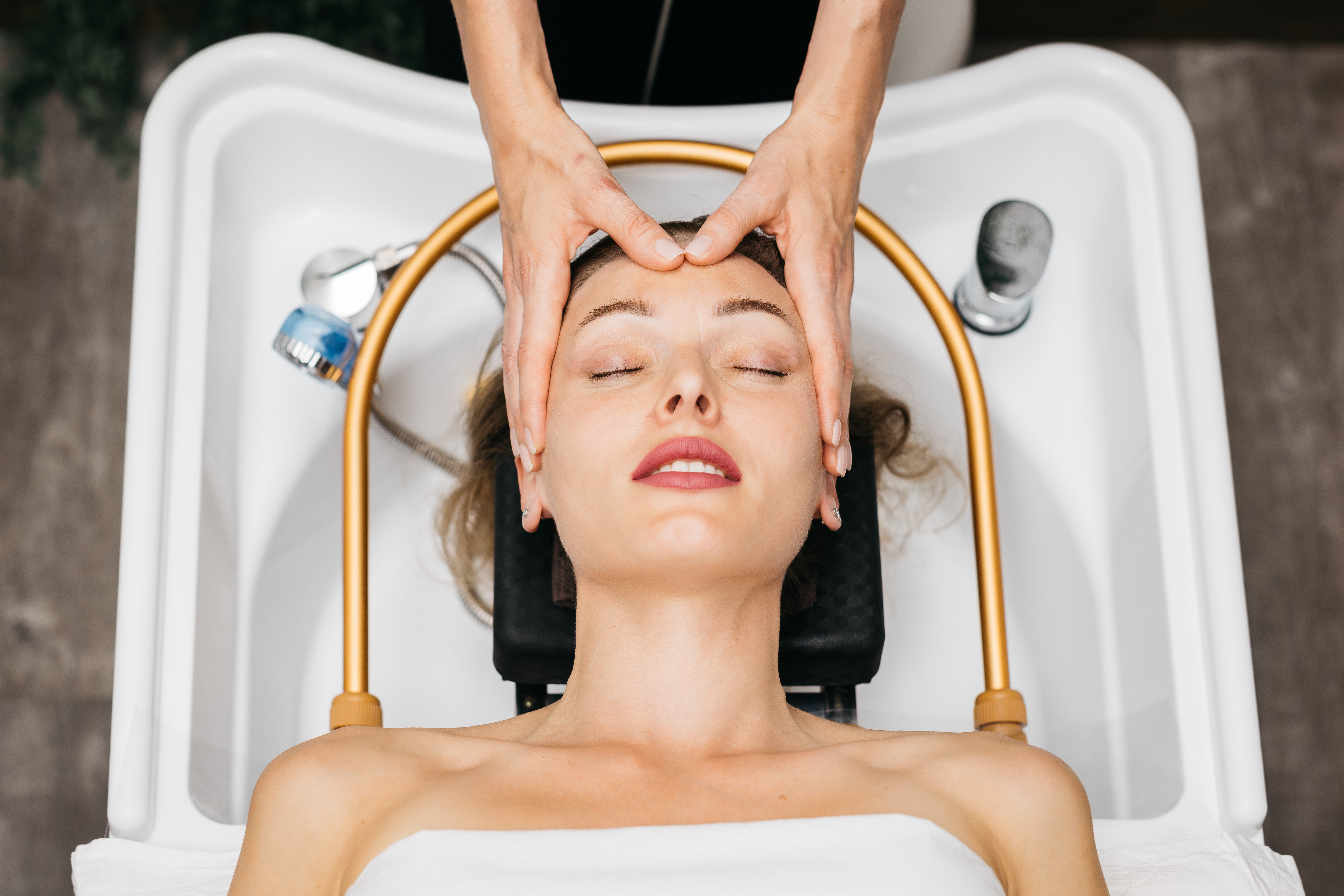 Zen image of a woman receiving a head spa treatment with water flowing. Used in homepage slider.